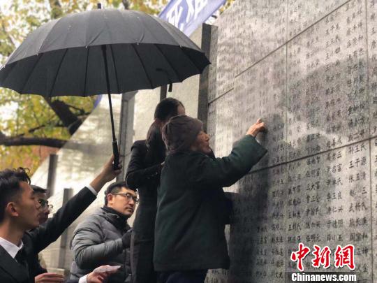 夏淑琴老人用手撫摸著親人的名字?！≈鞎苑f 攝